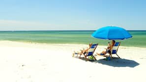 On the beach, white sand, sun loungers, beach umbrellas