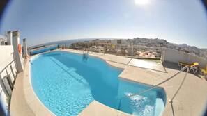 Una piscina al aire libre, sombrillas, tumbonas