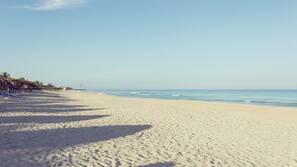 Sulla spiaggia, sabbia bianca, lettini da mare, ombrelloni