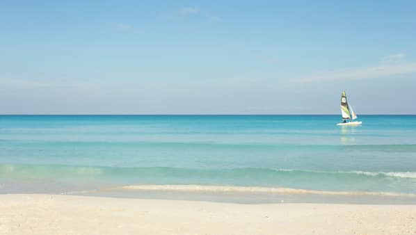 Sulla spiaggia, sabbia bianca, lettini da mare, ombrelloni