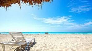 Plage, sable blanc, chaises longues, parasols