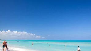 Plage, sable blanc, chaises longues, parasols