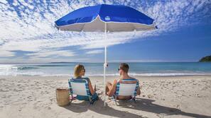 On the beach, white sand, beach umbrellas, beach towels