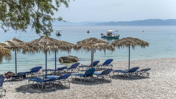 On the beach, white sand, sun loungers, beach umbrellas