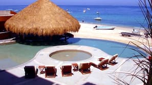 Una piscina al aire libre, sombrillas, tumbonas