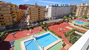 Una piscina al aire libre de temporada, sombrillas, tumbonas