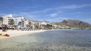 Am Strand, weißer Sandstrand, Sonnenschirme, Strandtücher