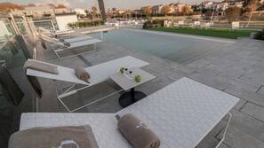 Piscine couverte, piscine extérieure, parasols de plage, chaises longues