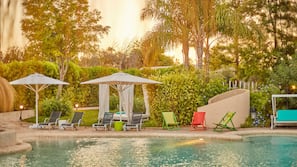 Una piscina al aire libre, sombrillas, tumbonas