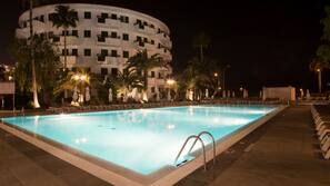 Una piscina al aire libre, sombrillas, tumbonas