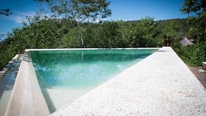 Una piscina al aire libre, tumbonas
