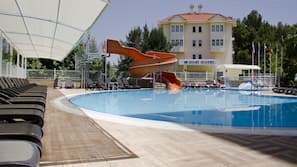 Una piscina al aire libre, sombrillas, tumbonas