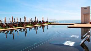 Una piscina al aire libre, sombrillas, tumbonas