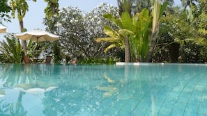 Outdoor pool, an infinity pool, pool umbrellas, sun loungers