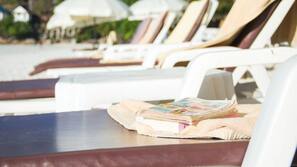 On the beach, sun-loungers, beach umbrellas, beach bar