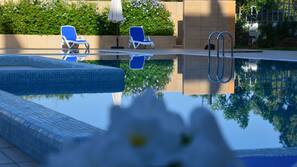 Piscine extérieure, parasols de plage, chaises longues