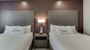 Premium bedding, desk, laptop workspace, blackout drapes