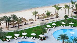 Een privéstrand, wit zand, parasols