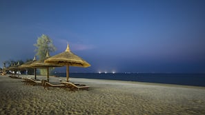Een privéstrand, wit zand, parasols