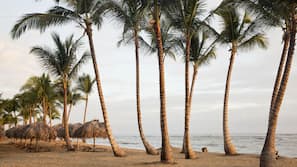 Am Strand, weißer Sandstrand, Liegestühle, Sonnenschirme