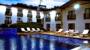 Una piscina al aire libre, tumbonas