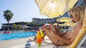 Piscine extérieure, parasols de plage, chaises longues