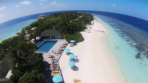 On the beach, white sand, sun loungers, beach umbrellas