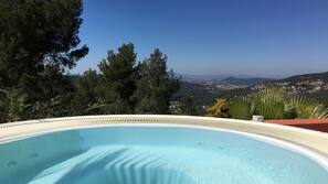 Una piscina al aire libre de temporada, sombrillas, tumbonas