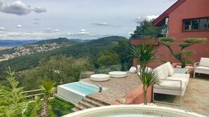 Una piscina al aire libre de temporada, sombrillas, tumbonas