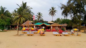 On the beach, white sand, sun-loungers, beach umbrellas