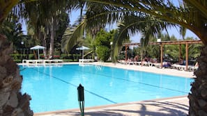 Piscine extérieure, parasols de plage, chaises longues