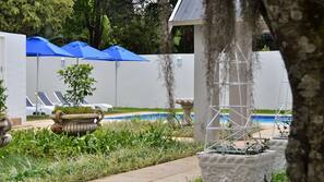 Piscine extérieure, parasols de plage, chaises longues