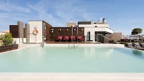 Una piscina al aire libre, tumbonas