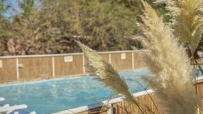 Una piscina al aire libre, tumbonas