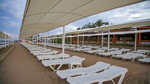 Privatstrand, schwarzer Sandstrand, Liegestühle, Sonnenschirme