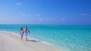 On the beach, white sand, sun-loungers, beach towels