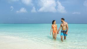 On the beach, white sand, sun-loungers, beach towels