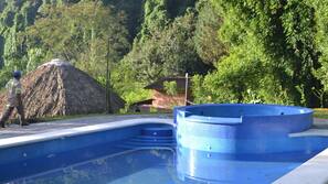 Una piscina al aire libre de temporada, sombrillas, tumbonas