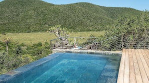 Outdoor pool, an infinity pool, pool umbrellas, pool loungers
