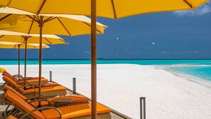 On the beach, white sand, beach umbrellas, beach towels