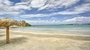 On the beach, white sand, sun loungers, beach umbrellas