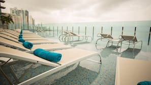 Una piscina al aire libre, tumbonas