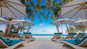 On the beach, white sand, sun-loungers, beach umbrellas