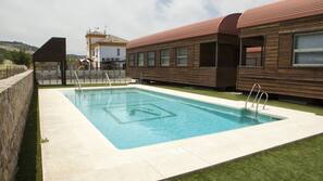 Una piscina al aire libre de temporada, sombrillas