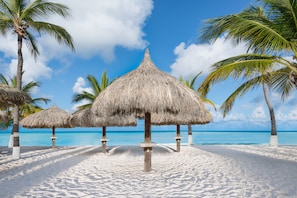 On the beach, white sand, sun loungers, beach umbrellas