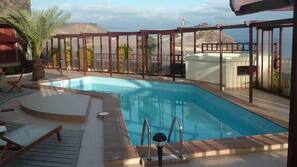 Piscina externa, guarda-sóis, espreguiçadeiras