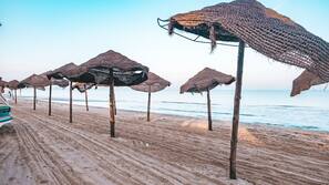 Praia particular, espreguiçadeiras, guarda-sóis, toalhas de praia