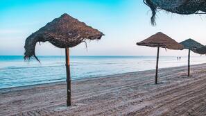 Praia particular, espreguiçadeiras, guarda-sóis, toalhas de praia