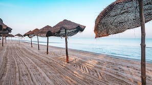 Praia particular, espreguiçadeiras, guarda-sóis, toalhas de praia