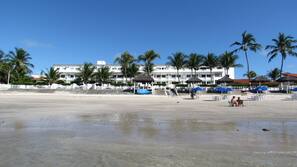 Na praia, areia branca, barracas de praia de cortesia